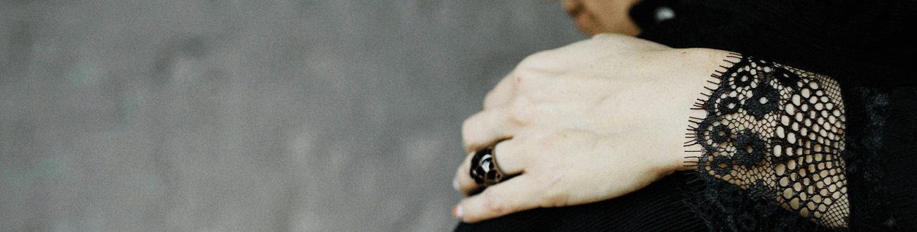 Mourning woman in black lace considering the cheapest funeral plans for her loved one.